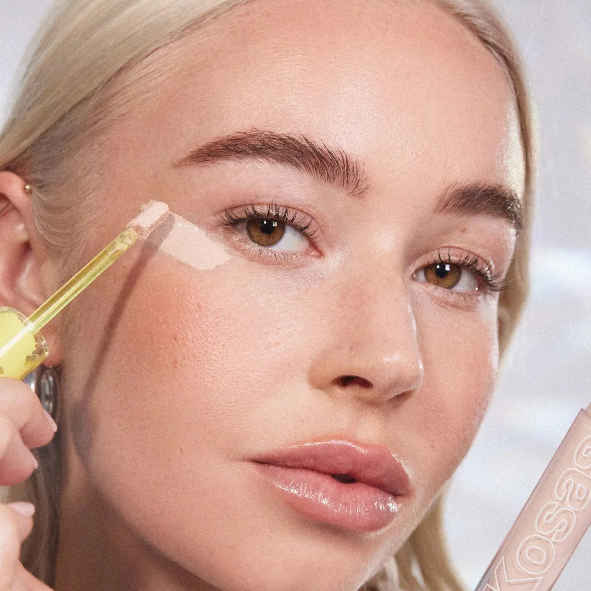 A model with concealer applied under one eye